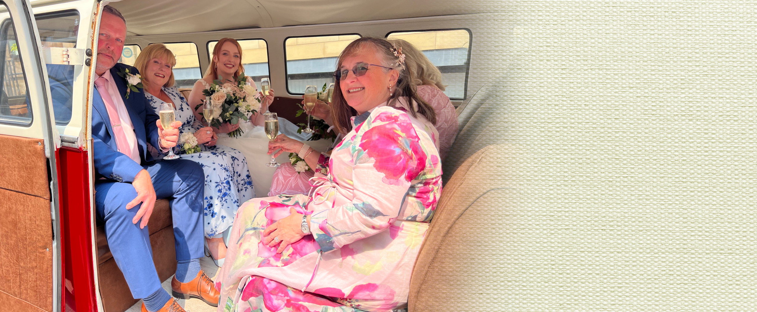 Wedding guests enjoying champagne inside the VW campervan wedding car